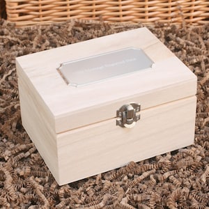 May include: A light wood box with a silver engraved plate that says "Our Wedding Engraved Box". The box has a silver latch.