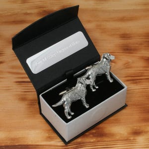 May include: A black gift box with a silver inscription that reads "For Murray, Engraved Here". The box contains two silver cufflinks shaped like Labrador Retrievers.
