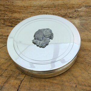 May include: A silver round trinket box with a raised pewter design of a Cocker Spaniel dog's head on the lid.