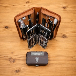 May include: A brown leather grooming kit case containing various stainless steel tools including scissors, tweezers, clippers, and a small spray bottle. The closed case features a metal plate with the text Your Message Engraved Here Free Of Charge.