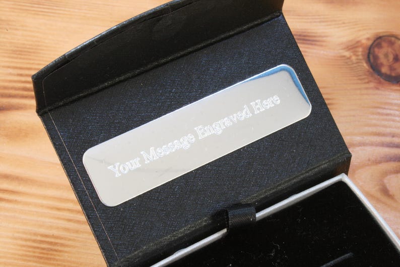 May include: A black gift box with a silver plaque that reads "Your Message Engraved Here".