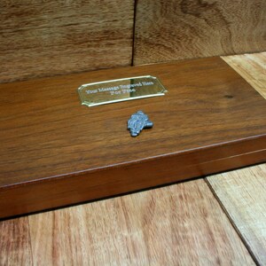 May include: A wooden box with a gold plaque that says "Your Message Engraved Here For Free". A small silver figurine of a person riding a motorcycle is on the box.