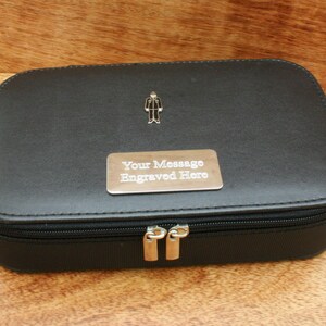 Könnte beinhalten: Schwarze Reißverschlusstasche mit einer silbernen Metallplatte, auf der "Your Message Engraved Here" steht.