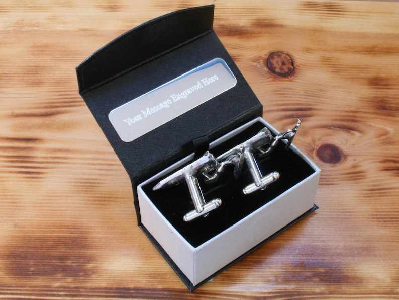 May include: A black gift box with a silver cufflink set inside. The box has a silver plaque that says "Your Message Engraved Here".