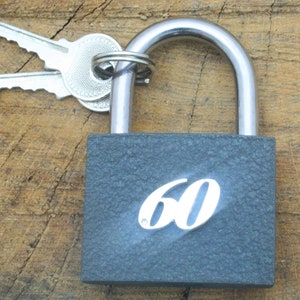 May include: A black padlock with a silver shackle and a silver keyhole. The padlock has a number "60" printed on the front.