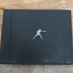 May include: Black leather photo album with a silver metal boxer figurine on the front cover.