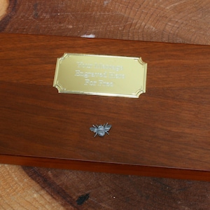 May include: A wooden box with a brass plaque that reads "Your Creativity Engraved for Ever" and a small bee figurine.