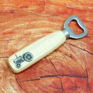May include: A wooden bottle opener with a metal opener and a metal tractor design on the handle.