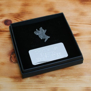 Könnte beinhalten: Eine silberne Metallkarte der Isle of Man in einer schwarzen Samtbox mit einer silbernen Plakette mit der Aufschrift "Thomas Jackson, geboren 1978, lebte auf der Isle of Man, 1978-2023".