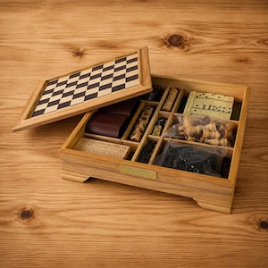 May include: A wooden game box with a removable checkerboard lid, containing compartments filled with various game pieces including dominoes, dice, and chess pieces in plastic bags, plus a cribbage board, featuring a small brass nameplate.