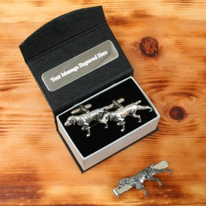 May include: A set of silver cufflinks and a tie clip featuring a hunting dog design. The cufflinks are in a black box with a silver plate that says "Your Message Engraved Here".