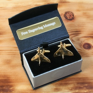 May include: Gold cufflinks in the shape of a jet plane, in a black and silver gift box with a label that says "Free Engraving Message".