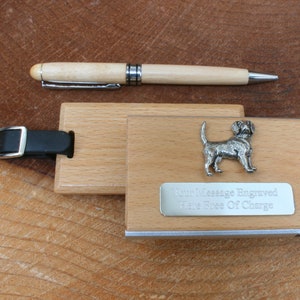 May include: A wooden luggage tag with a silver beagle dog charm and a silver plate that says "Your Message Engraved Here Free Of Charge". The tag has a black leather strap with a silver buckle. A wooden pen is also included.