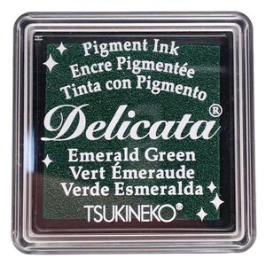 May include: A green ink pad with the text "Pigment Ink", "Encre Pigment&eacute;e", "Tinta con Pigmento", "Delicata", "Emerald Green", "Vert &Eacute;meraude", "Verde Esmeralda", and "TSUKINEKO&reg;".