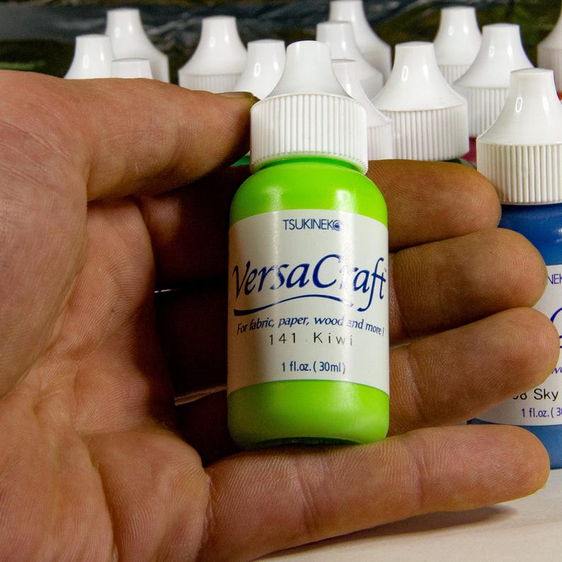 K&ouml;nnte beinhalten: Eine gr&uuml;ne Flasche VersaCraft-Farbe mit der Aufschrift "141 Kiwi" und einem wei&szlig;en Verschluss. Die Flasche enth&auml;lt 30 ml.