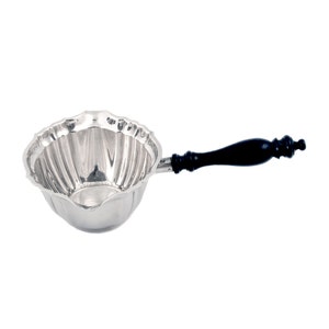 May include: A silver serving ladle with a fluted bowl and a black wooden handle.