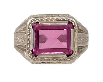 Könnte beinhalten: Ein silberner Ring mit einem verzierten Design und einem rosafarbenen Edelstein in der Mitte.