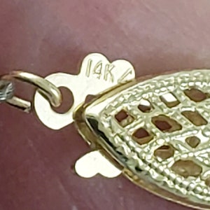 May include: A gold chain necklace with a 14K clasp. The chain is made of a delicate, intricate design.