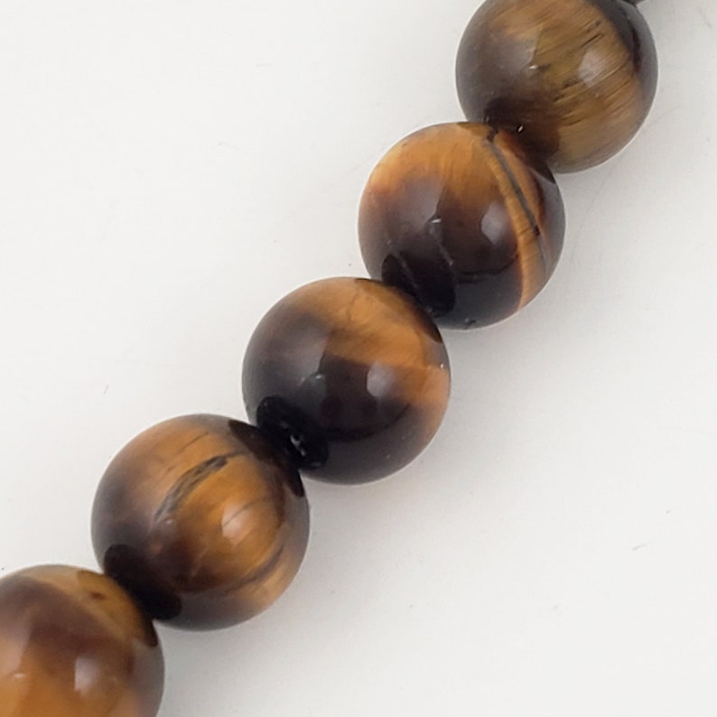 May include: A strand of tiger's eye beads. The beads are round and have a golden brown color with a subtle shimmer.