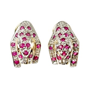 May include: A pair of gold earrings with a snake design. The earrings are set with red rubies and white diamonds.