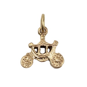 May include: A gold-colored charm in the shape of a horse-drawn carriage. The carriage has a detailed design with a rounded roof and two wheels.