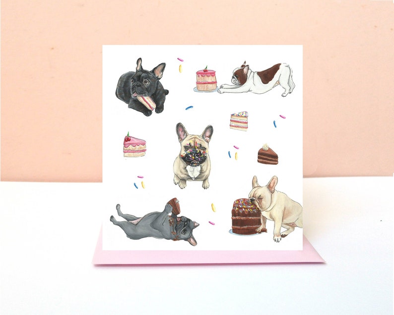 May include: A square greeting card featuring a white background with illustrations of French bulldogs in various colors, including black, fawn, and white with brown patches, interacting with colorful slices of cake and scattered sprinkles.