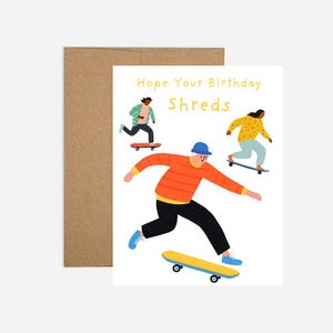 May include: Greeting card with a brown envelope. The card features illustrations of three people skateboarding, with the text "Hope Your Birthday Shreds" in yellow. The skaters are wearing colorful outfits.
