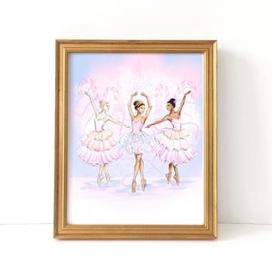 May include: A framed print featuring three ballerinas in pink and white tutus, pointe shoes, and tiaras. The background is a soft pink and blue with a decorative design. The frame is gold.