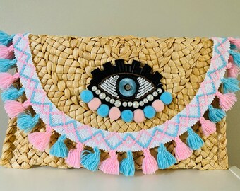 Pochette in paglia rosa e blu con occhio di Allah, realizzata a mano e con nappine.