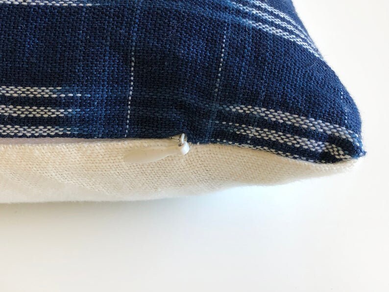 May include: A blue and white striped pillow cover with a zipper closure. The pillow cover is made of a soft, woven fabric.