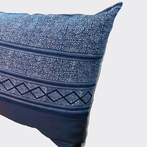 Puede incluir: Un coj&iacute;n decorativo con un patr&oacute;n geom&eacute;trico en azul marino y blanco. El coj&iacute;n presenta un dise&ntilde;o detallado de diamantes, c&iacute;rculos y l&iacute;neas. La parte inferior del coj&iacute;n es de color azul marino liso.