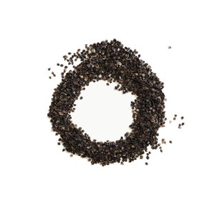May include: A circle of dark brown buckwheat groats on a white background.