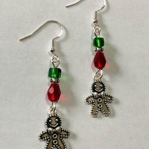 Pode incluir: Brincos de homem de gengibre prateados com contas de cristal vermelhas e verdes.