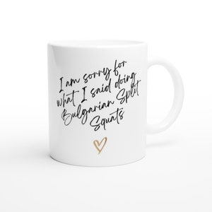 May include: White ceramic mug with black text that reads "I am sorry for what I said doing Bulgarian Split Squats" with a gold heart at the bottom.