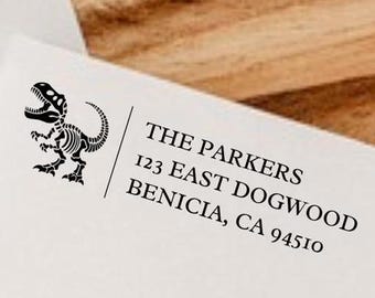 May include: A white envelope with a black dinosaur skeleton graphic and the text "THE PARKERS 123 EAST DOGWOOD BENICIA, CA 94510"