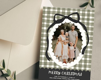 May include: A green and white gingham Christmas card with a black bow and a photo of a family of seven in a white circle. The text "Merry Christmas" is written in black script with the family name and names of each family member below.