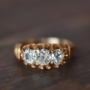 1880s 18K Antique 1.35 Carat Total Weight Old Mine Cut Diamond Three Stone Ring in Yellow Gold
