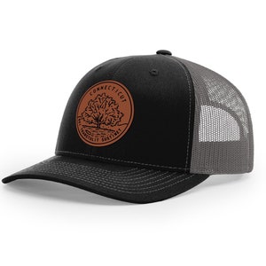 May include: Black and gray trucker hat with a brown leather patch featuring a tree and the text "CONNECTICUT TRANSPLANT SUSTAIN",