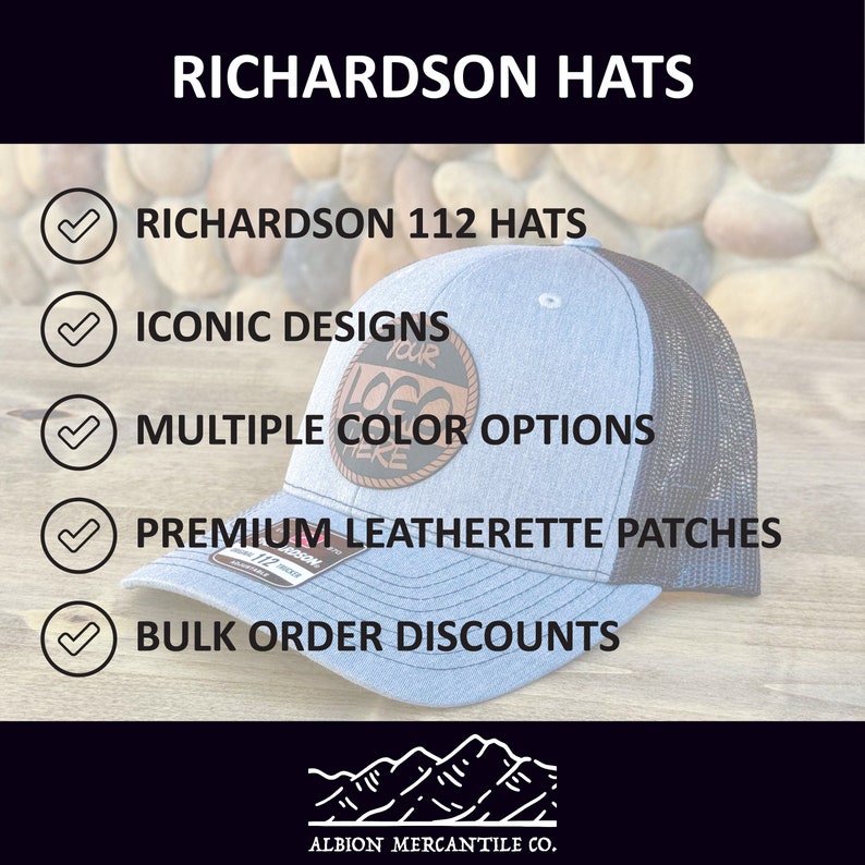 May include: A blue and black Richardson 112 hat with a brown leatherette patch that says "Your Logo Here". The hat is on a wooden surface with a background of rocks. The text "RICHARDSON HATS" is at the top of the image. The text "ICONIC DESIGNS", "MULTIPLE COLOR OPTIONS", "PREMIUM LEATHERETTE PATCHES", and "BULK ORDER DISCOUNTS" are listed below the hat. The text "ALBION MERCANTILE CO." is at the bottom of the image.
