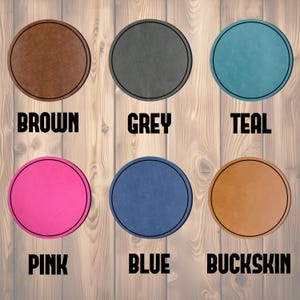 May include: A collection of six round coasters in various colors, including brown, grey, teal, pink, blue, and buckskin. Each coaster has a black border and a corresponding color name printed below.