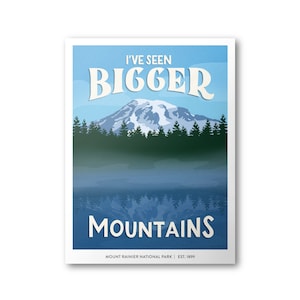 May include: A vintage-style poster with a blue sky and a mountain range reflected in a lake. The text reads "I've Seen Bigger Mountains" and "Mount Rainier National Park | Est. 1899".