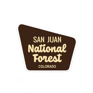 May include: A brown and white sticker with the text "San Juan National Forest Colorado".