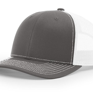 May include: A gray and white trucker hat with a mesh back. The hat has a white stitching detail around the brim.