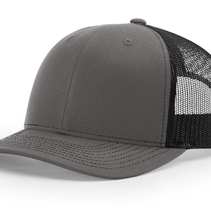 May include: A gray and black trucker hat with a mesh back. The hat has a curved brim and a structured crown.