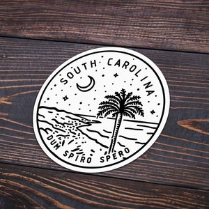 May include: Black and white illustration of a palm tree on a beach with a crescent moon and stars in the sky. The text "South Carolina" is written in a circle around the image. The text "Dum Spiro Spero" is written below the image.