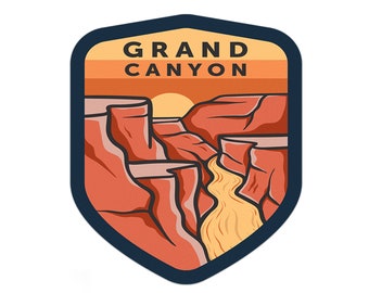 Op de afbeelding: Een blauwe en oranje geïllustreerde patch met de tekst "GRAND CANYON" en een afbeelding van een canyon met een rivier die erdoorheen stroomt.