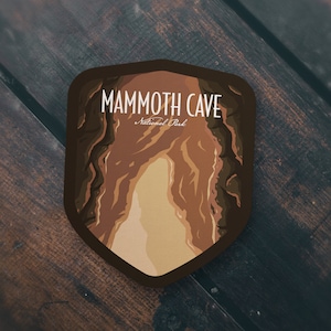 May include: A brown and tan illustrated sticker of Mammoth Cave National Park. The sticker features a stylized image of the cave entrance with the text "Mammoth Cave National Park" above it.