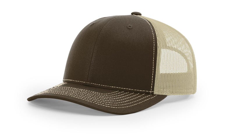 May include: A brown and beige trucker hat with a mesh back. The hat has a curved brim and a white stitching detail.