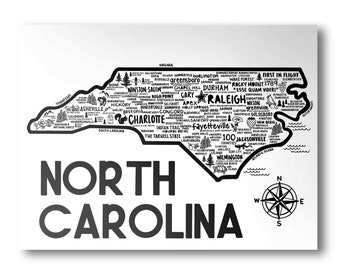 May include: A black and white map of North Carolina with the state's name in large bold letters at the bottom. The map is filled with city names and points of interest, including "First in Flight", "The Tarheel State", and "100 Counties". A compass rose is in the lower right corner.