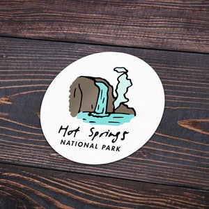 May include: A white circle sticker with a cartoon illustration of a waterfall and the text "Hot Springs National Park".